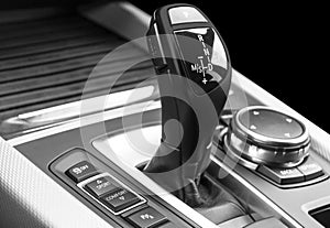 Automatic gear stick of a modern car, car interior details, close up. Car detailing. Black and white. Automatic transmission lever