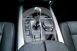 Automatic gear stick transmission of a modern car, multimedia and navigation control buttons. Car interior details. Transmission