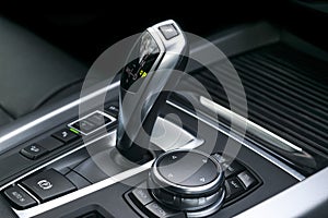 Automatic gear stick transmission of a modern car, multimedia and navigation control buttons. Car interior details. Transmission