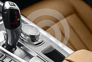 Automatic gear stick transmission of a modern car. Multimedia and navigation control buttons. Car interior details. Transmission s