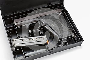 Automatic gun and bullets in a plastic hard case on white background