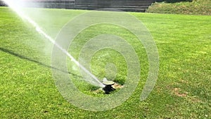 Automatic irrigate sprinkle watering grass at football field