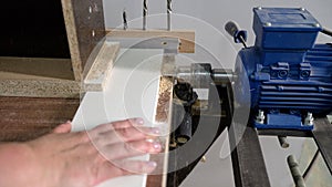 Automatic machine tool makes holes in wooden details of furniture. Furniture production, a machine makes a hole, close