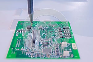 Automatic manipulator with dispenser needle during work with SMT pcb - close up