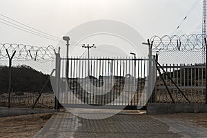 Automatic metal gate. Barbed wire fence block the way. gate to a closed area