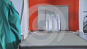 Automatic packaging of plastic bottles with film in the temperature press. Packaging of bottles for further