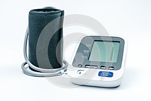 Automatic portable blood pressure machine with arm cuff on white, studio shot.