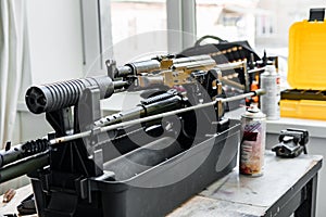 Automatic rifle on stand on the table of the weapons workshop.