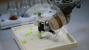 Automatic robot pharmaceutical industry. Robot automatically sorting balls. Robot sorts pills by color