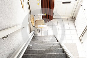 Automatic stair lift on staircase taking elderly people and disabled persons up and down in a house