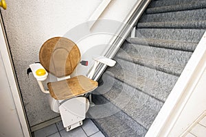 Automatic stair lift on staircase taking elderly people and disabled persons up and down in a house