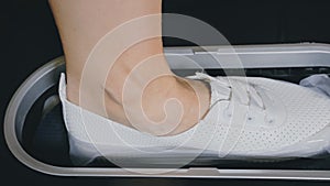 Automatic Thermal Shrinkable Shoe Cover Laminating Machine. Close up. Machine automatically applies shoe covers to the