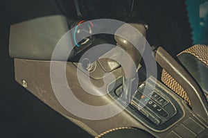 Automatic transmission lever in the interior of an old car. Dust and scratches on the surfaces of the car. A look