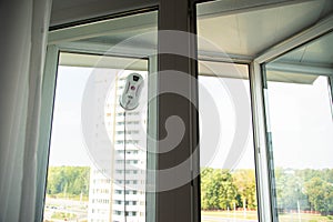 Automatic vacuum robot window cleaner washes glass in the apartment, balcony frame,