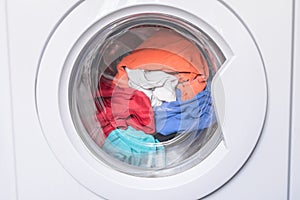 Automatic washer with open door. Erasing home t-shirts. Dirty clothes are inside the washing machine