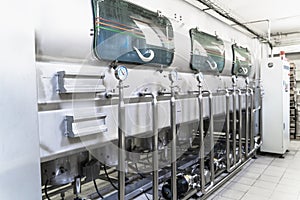 Automatic washing machine conveyor with blue plastic bottles inside in water manufacturing factory