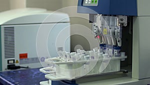 Automatic work with analysis in the laboratory. Electronic equipment in the lab working with test tubes close up. Drug