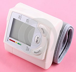 Automatic Wrist Digital blood pressure monitor on pink background at dry day