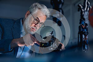 Automation, robotics engineer working on mechanical system of robotic arm. Concept of modern technology in industries