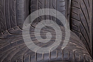 Automobile composition made up stack of tires and wheel with shiny disc in a car service before seasonal replacement or after