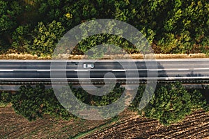Automobile on highway road, top view aerial shot from drone pov