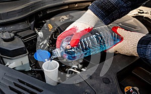 Automobile Maintenance. Filling the Windshield Washer Fluid on a Car