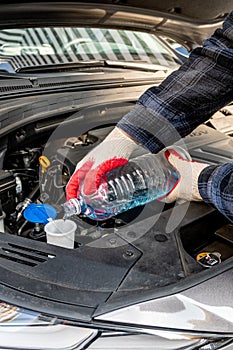 Automobile Maintenance. Filling the Windshield Washer Fluid on a Car