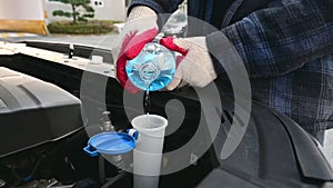 Automobile Maintenance. Filling the Windshield Washer Fluid on a Car