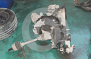 An automobile manual transmission with a semi-axle is lying on the floor