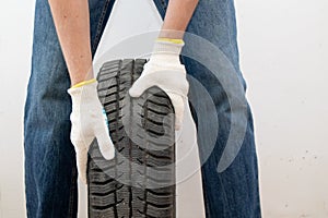 Automobile mechanic with car tire. Car wheel replacement