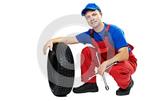 Automobile mechanic with car tire and spanner