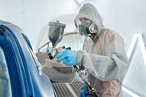 automobile repairman painter hand in protective glove with airbrush pulverizer