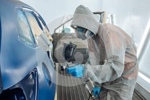 automobile repairman painter hand in protective glove with airbrush pulverizer