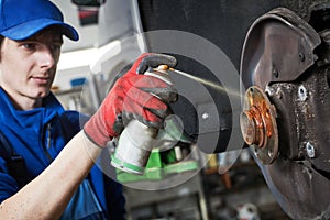 Automobile service. Lubricating car hub while disk and brake pads replacement in repair shop or garage