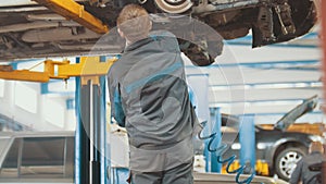 Automobile service - mechanic wrapping working device under car bottom