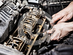 Automobile service worker or garage mechanic repairing auto car engine