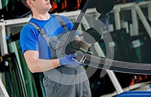 Automobile special workers replacing windscreen of a car in auto service