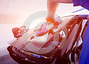 Automobile special workers replacing windscreen of a car in auto service