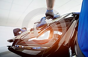 Automobile special workers replacing windscreen of a car in auto service