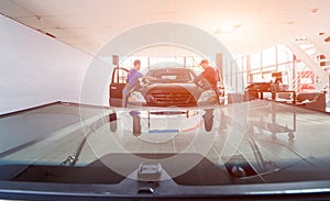 Automobile special workers replacing windscreen of a car in auto service