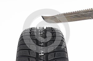 Automobile tire and knife isolated on white background