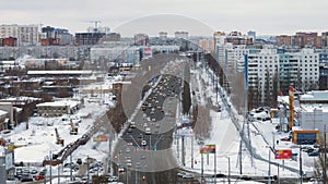 Automobiles are moving over road in city in winter day, top view