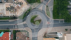 Automobiles riding ring road in small city top view. Round traffic at cozy town