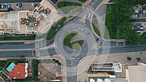 Automobiles riding ring road in small city top view. Round traffic at cozy town