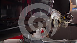 Automotive brake disc service performed with precision lathe. Mechanic repairs car rotor using specialized aligner