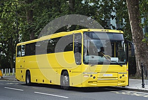 Automotive: Bright yellow private hire coach. 1