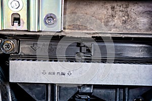 Automotive cabin air filter direction of flow arrow marked on casing.