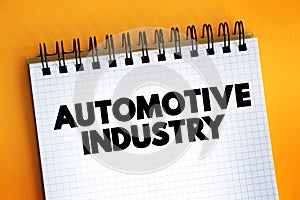 Automotive industry - companies and activities involved in the manufacture of motor vehicles, text concept on notepad