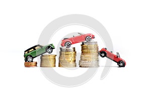 Automotive industry evolution concept with colored toy cars on pile of coins