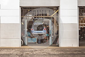 Automotive Maintenance: Car on Lifting Platform in Garage for Repairs and Inspection, Mechanic's Workshop